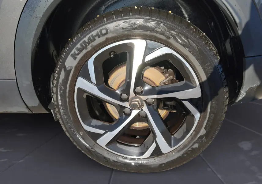 Gros plan sur la roue avant droite du Citroën C5 Aircross gris platinium avec jante alliage bi-ton et pneu Kumho.