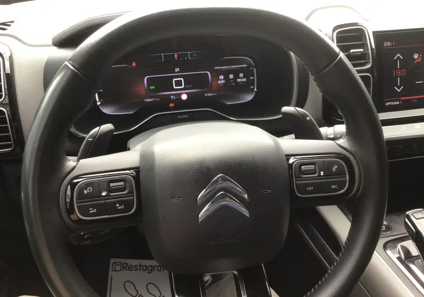Vue rapprochée du volant noir du Citroën C5 Aircross 2020 avec tableau de bord numérique et commandes intégrées.