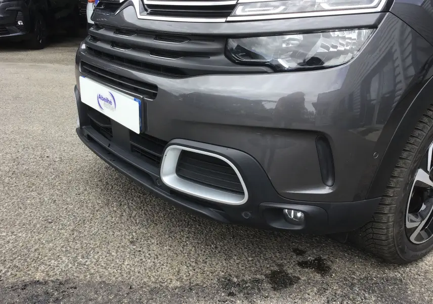 Gros plan sur l’avant droit du Citroën C5 Aircross gris platinium, mettant en valeur la calandre et les phares LED.