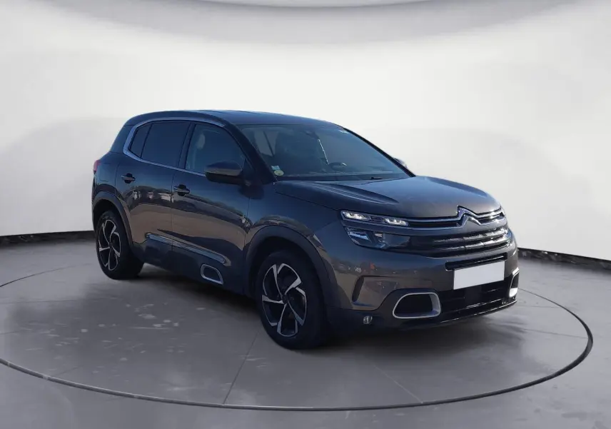Citroën C5 Aircross gris platinium en 3/4 avant droit, avec jantes bi-ton et calandre distinctive.