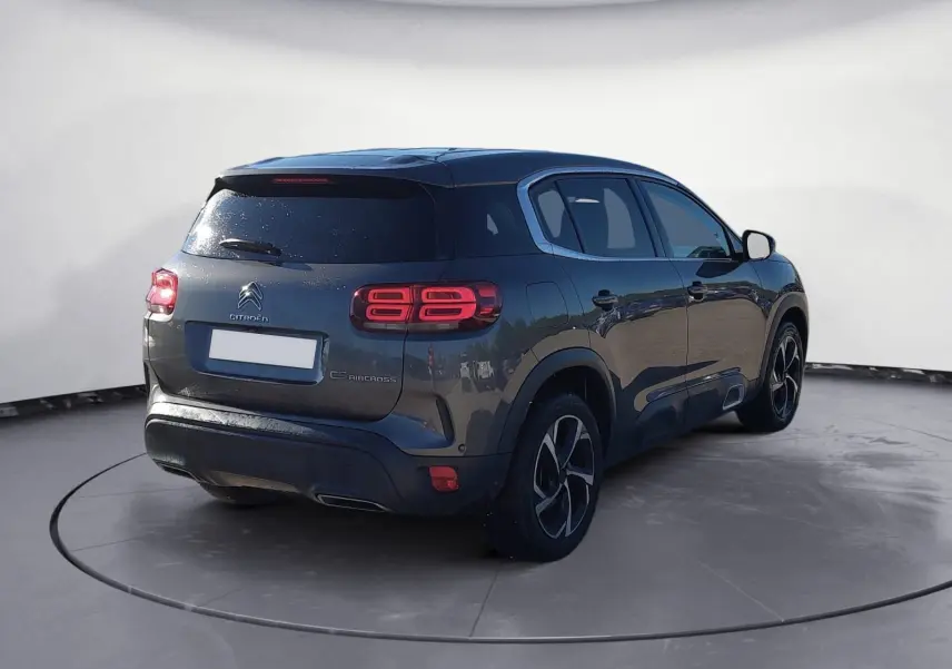 Vue 3/4 arrière droite d'un Citroën C5 Aircross gris platinium avec feux arrière LED et jantes bi-ton 18 pouces.