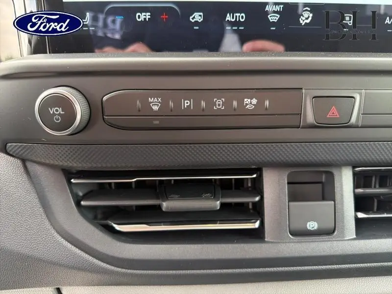 Détail du tableau de bord gris du Ford Transit Custom Fourgon 2026 avec commandes clim et bouton volume.