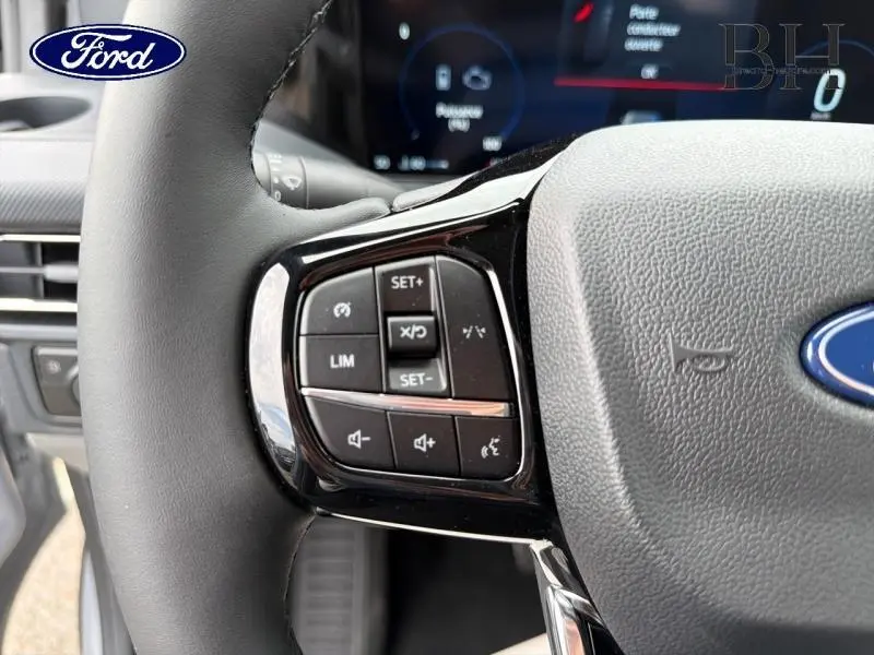 Gros plan sur les commandes de régulateur de vitesse au volant gris du Ford Transit Custom Fourgon 2026.