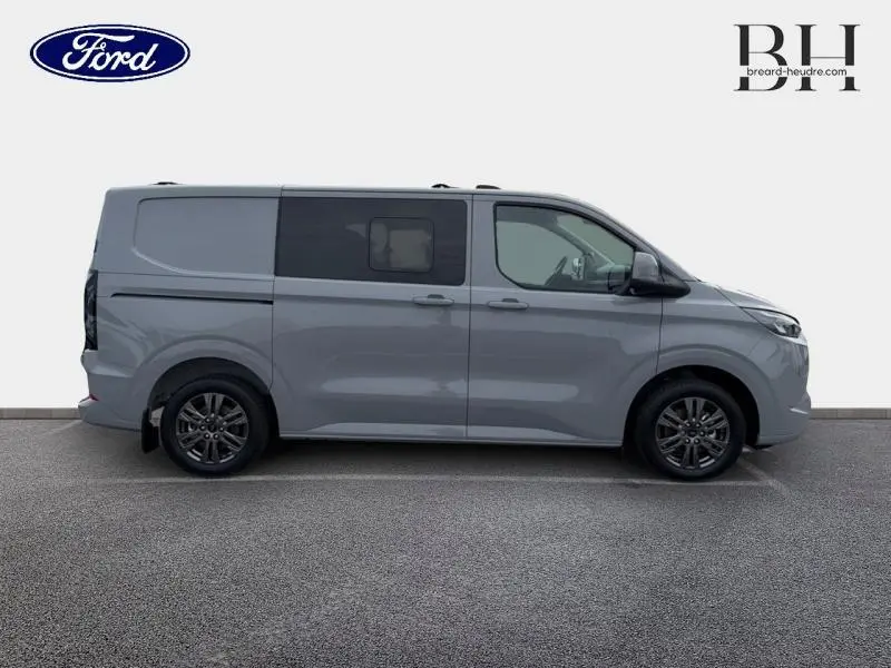 Vue de profil côté gauche du Ford Transit Custom Fourgon gris Matter Spéciale avec porte latérale coulissante double et jantes alu gris carbone.