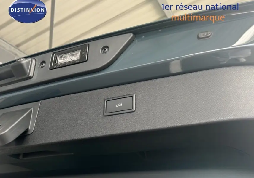Détail du bouton d'ouverture électrique du coffre sur le hayon bleu Fjord metal d'un CUPRA Formentor.