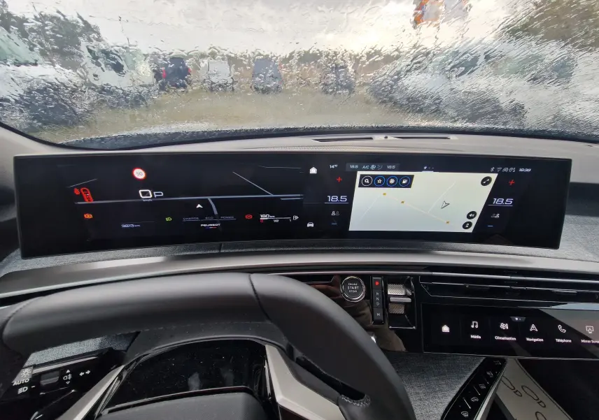 Vue intérieure du tableau de bord du Peugeot 3008 2025, écran panoramique 21 pouces avec affichage numérique et navigation.