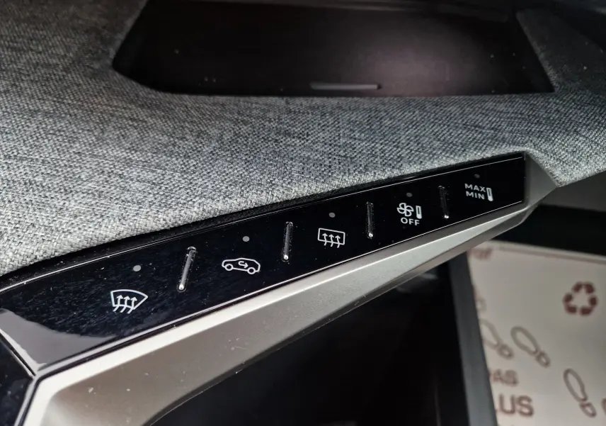 Détail de la console intérieure du Peugeot 3008 gris Artense, montrant les commandes tactiles de climatisation et désembuage.
