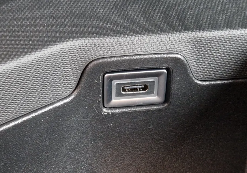 Gros plan sur un port USB-C intégré dans la garniture intérieure noire d'un Peugeot 3008 Gris Artense 2025.