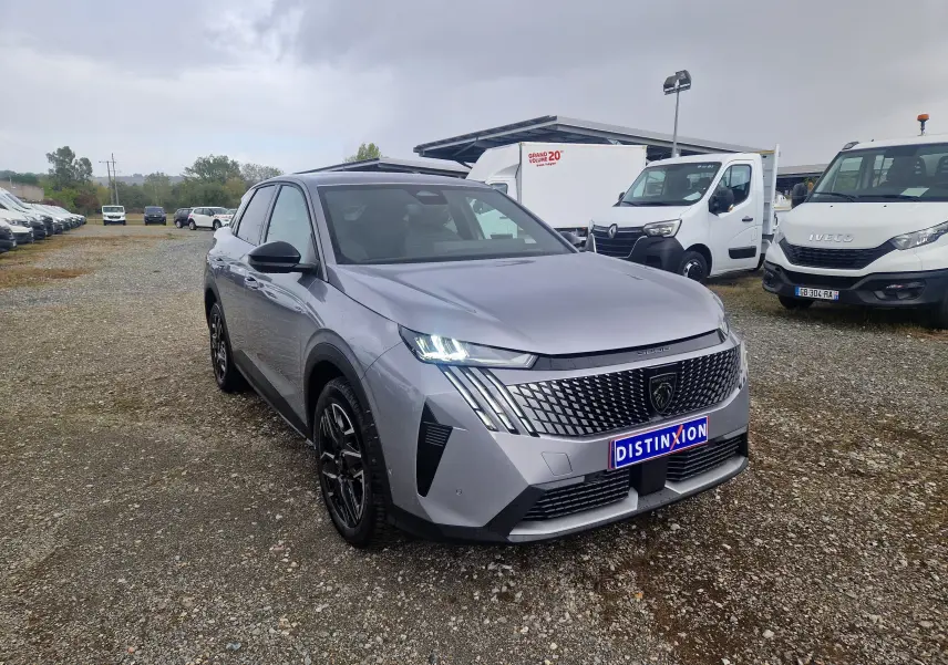 Peugeot 3008 gris Artense vue 3/4 avant droit, calandre distinctive avec logo lion et phares LED allumés.