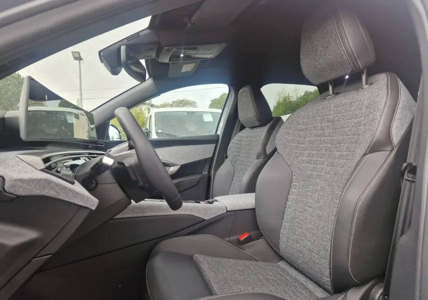 Vue intérieure côté conducteur du Peugeot 3008 2025, sièges tissu et cuir gris avec écran panoramique 21 pouces.