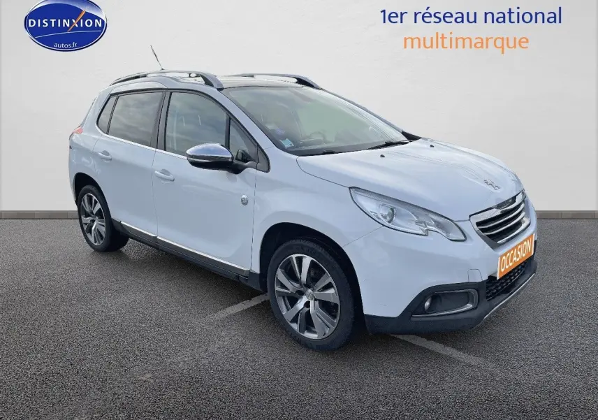 Peugeot 2008 blanc en 3/4 avant droit, avec jantes alliage et barres de toit visibles sur parking.