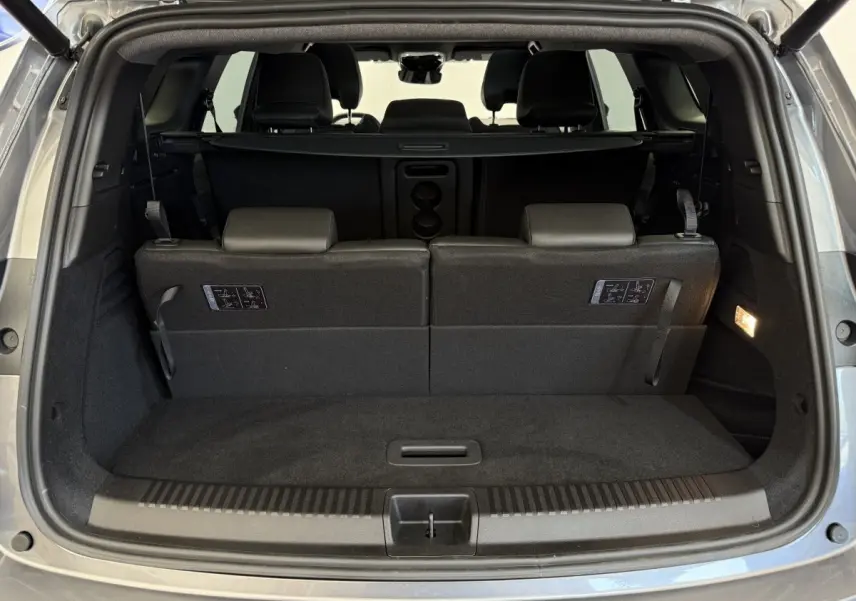 Coffre ouvert vu de l'arrière du Renault Espace gris foncé 2025 avec 3ème rangée de sièges rabattables et plancher plat.