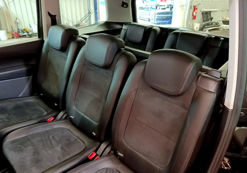 Vue intérieure montrant les sièges individuels noirs de la 2ème et 3ème rangée du Volkswagen Sharan 2017.