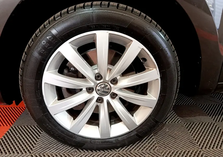 Gros plan sur la roue avant droite argentée du Volkswagen Sharan marron, mettant en valeur la jante à 10 branches.