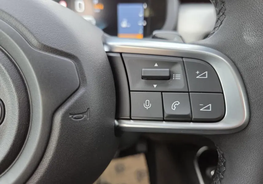 Gros plan sur les commandes vocales et téléphoniques au volant en TEP noir du Jeep Avenger 2025.