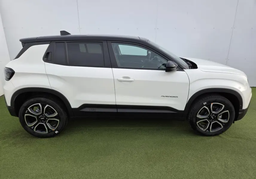 Profil côté gauche du Jeep Avenger 2025 blanc Snow avec toit noir Volcano et jantes alliage 18 pouces.