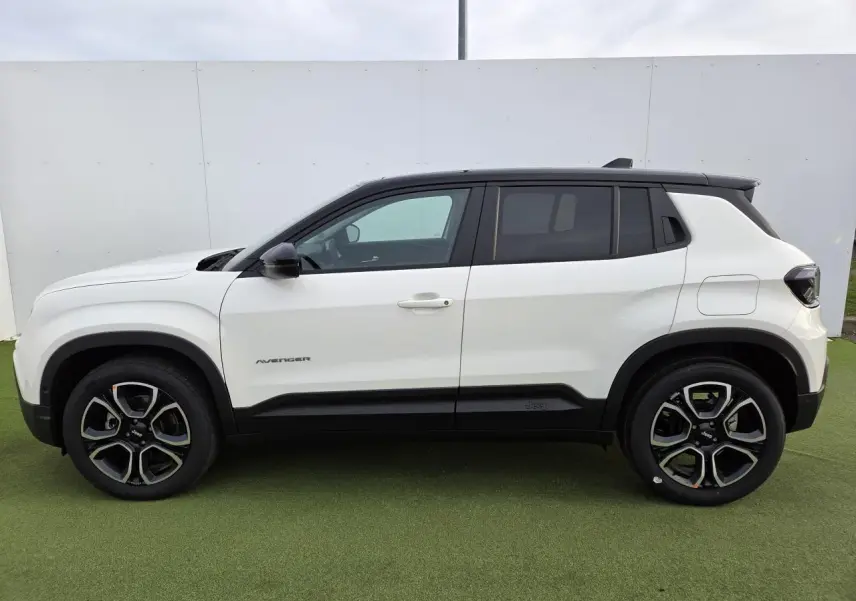 Profil côté gauche du Jeep Avenger 2025 blanc Snow avec toit noir Volcano et jantes alliage 18 pouces.