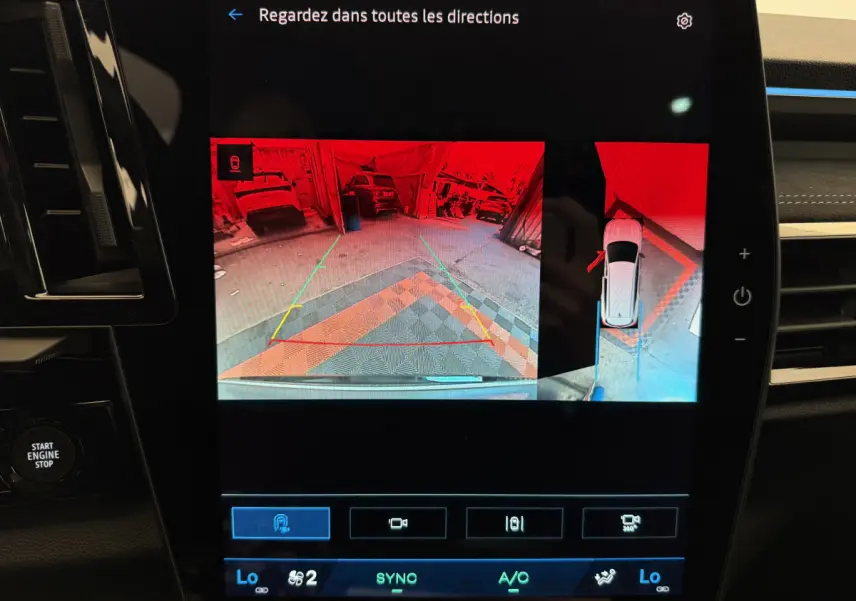 Écran tactile du tableau de bord du Renault Espace gris foncé 2025 montrant la caméra de recul et l'aide au stationnement.