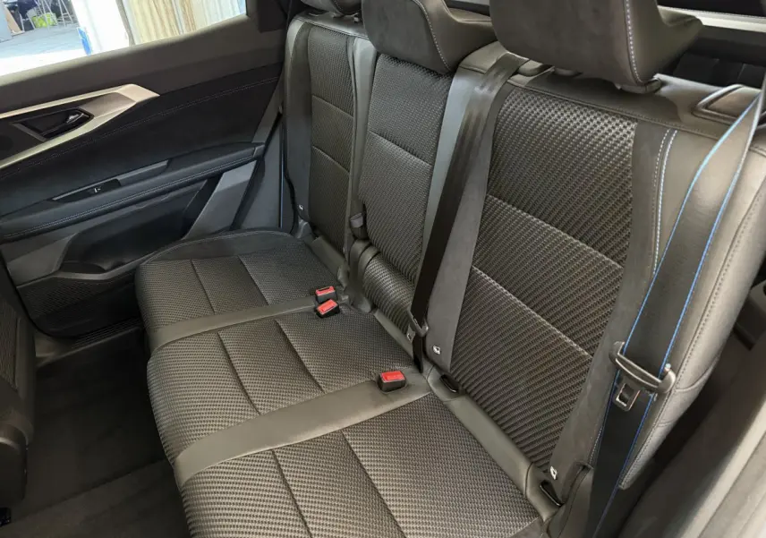 Vue intérieure côté droit sur la banquette arrière noire texturée avec surpiqûres bleues du Renault Espace esprit Alpine 2025.