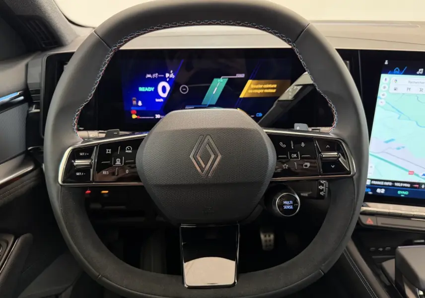 Vue rapprochée du volant en cuir et suède noir du Renault Espace esprit Alpine 2025 avec tableau de bord numérique et écran tactile.