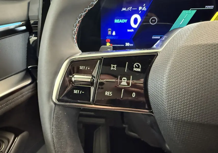 Gros plan sur le volant cuir noir et les commandes de régulateur de vitesse du Renault Espace gris foncé 2025 esprit Alpine.