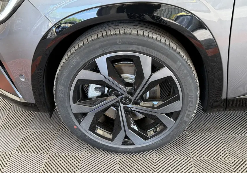 Gros plan sur la roue avant droite du Renault Espace gris foncé, jante alliage noire et grise au design moderne.