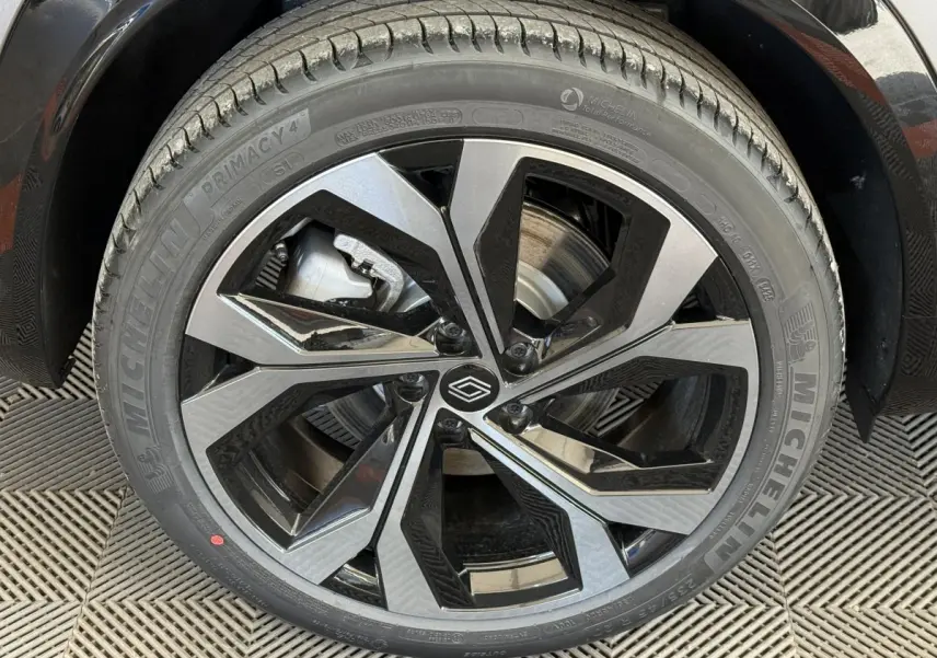 Gros plan sur la jante noire et argentée du côté gauche d’un Renault Espace gris foncé hybride 2025.