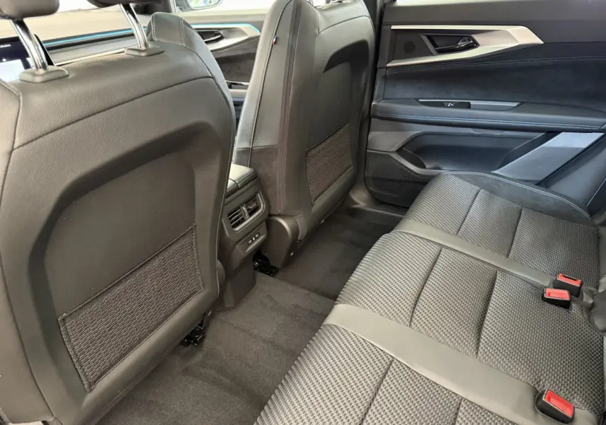 Vue intérieure arrière côté droit du Renault Espace gris foncé, sièges en tissu et cuir avec finitions modernes.