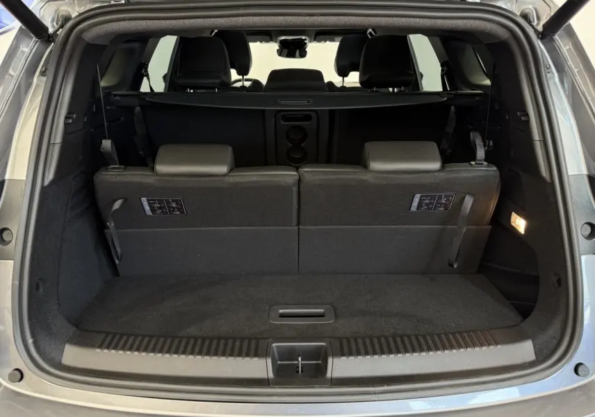 Coffre ouvert vu de l'arrière d'un Renault Espace gris foncé avec 3ème rangée de sièges rabattables et plancher plat.