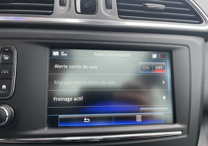 Écran central du Renault Kadjar gris titanium 2018 montrant les réglages d’aides à la conduite avec option sortie de voie désactivée.