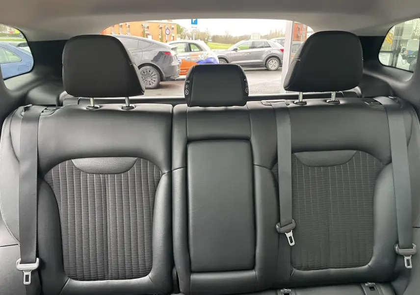 Vue arrière des sièges arrière en tissu gris noir du Renault Kadjar 1.5 DCI 110 EDC Bose avec appuie-têtes et ceintures visibles.