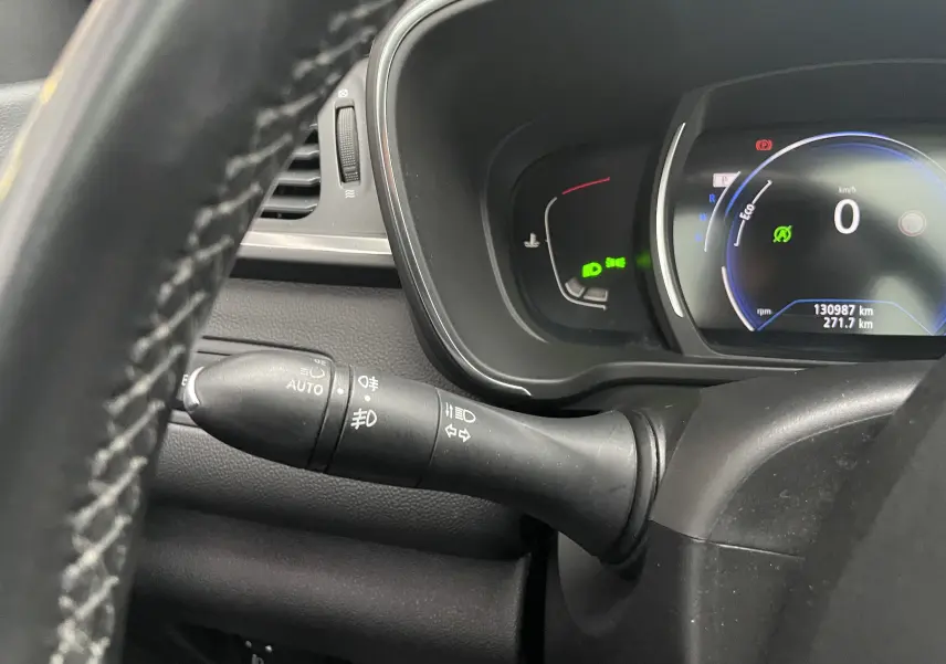 Gros plan sur le tableau de bord et la commande des phares du Renault Kadjar gris titanium, affichage numérique allumé.