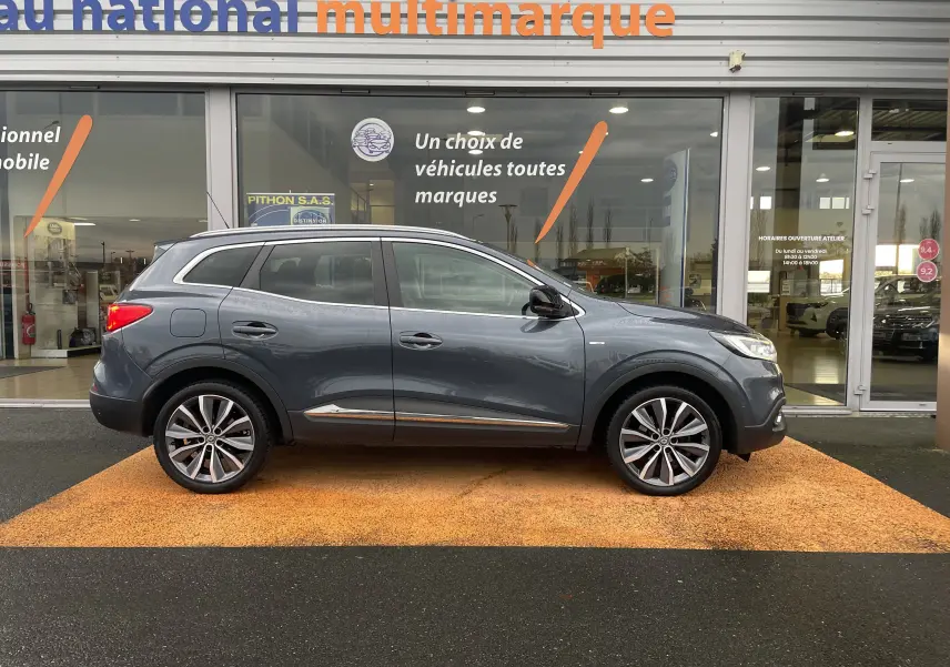 Renault Kadjar gris titanium vu de profil côté gauche, avec jantes alliage bi-ton et détails chromés.