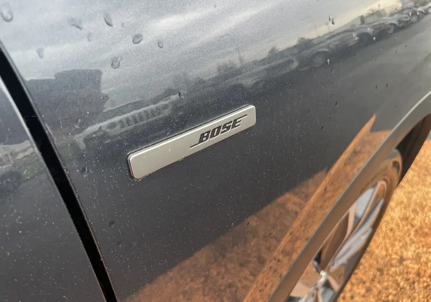 Gros plan sur l'écusson Bose sur la portière côté gauche d'un Renault Kadjar gris titanium.