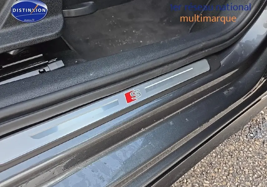 Gros plan sur la plaque de seuil de porte avec logo S de l'Audi A3 Sportback 45 TFSI e gris Daytona côté gauche.