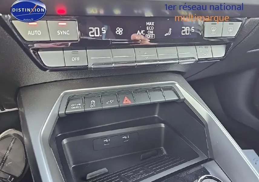 Vue rapprochée du tableau de bord et console centrale de l’Audi A3 Sportback 45 TFSI e gris Daytona, avec commandes climatisation et boutons fonctionnels.