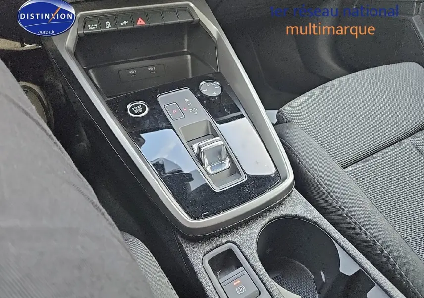 Gros plan sur la console centrale noire brillante et levier de vitesses automatique de l'Audi A3 Sportback 45 TFSI e 2024.