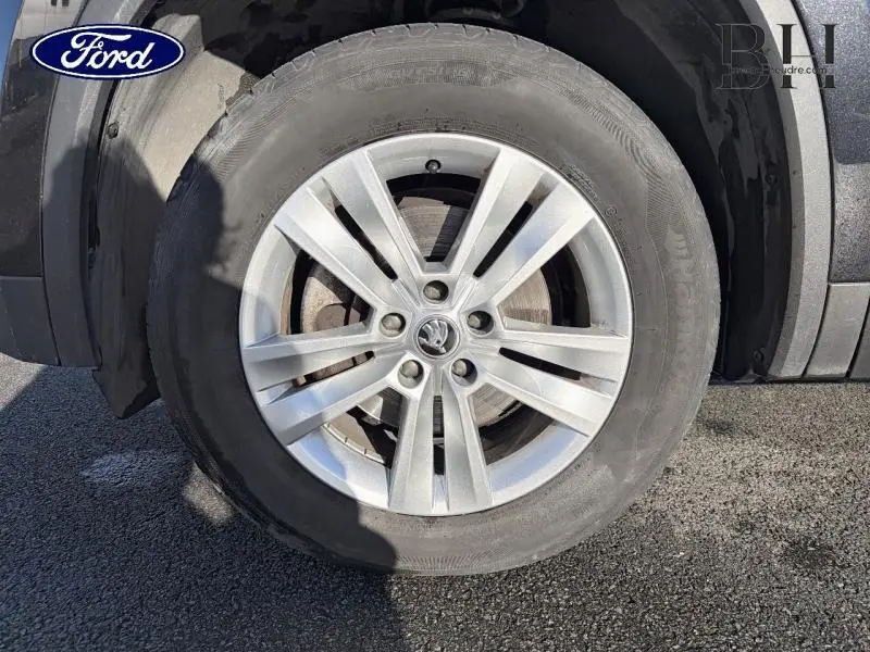 Gros plan sur la roue avant droite avec jante alu argentée du Skoda Kodiaq Noir Magic Nacré 2023.