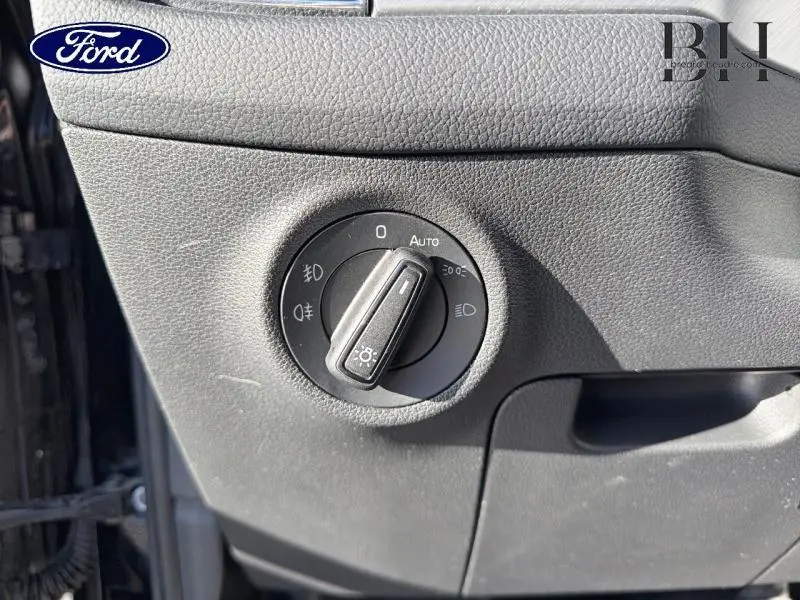 Commande des phares en gros plan sur tableau de bord noir d'un Skoda Kodiaq noir Magic Nacré, côté gauche.