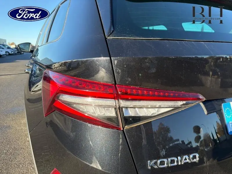 Gros plan sur le feu arrière gauche d’un Skoda Kodiaq noir Magic Nacré avec logo et badge visibles.
