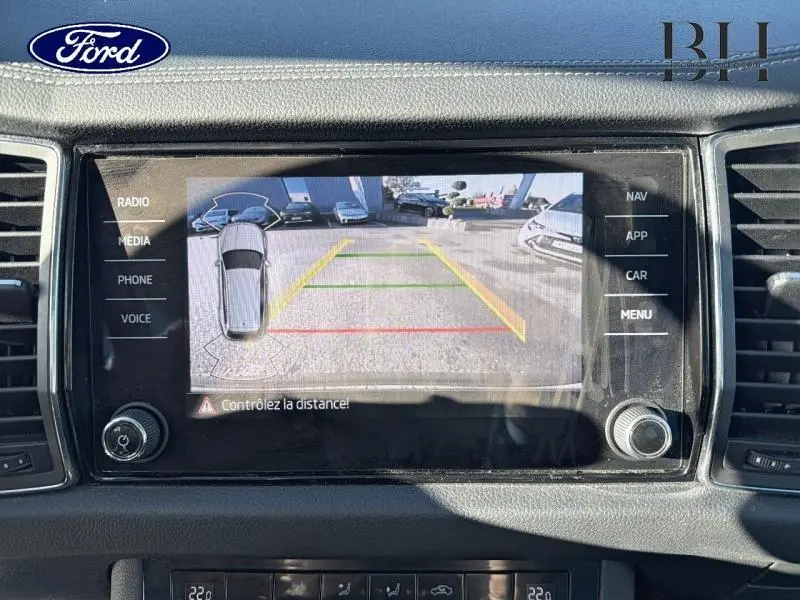 Vue de l'écran tactile central affichant la caméra de recul avec lignes de guidage, dans un Skoda Kodiaq noir.