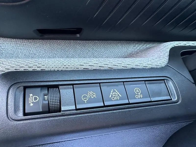 Gros plan sur les commandes d’aide à la conduite et réglage des phares dans l’habitacle de la Citroën C3 2025.