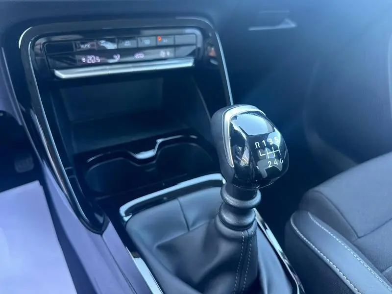 Gros plan sur le levier de vitesse manuel noir de la Citroën C3 1.2 Turbo 2025, avec console centrale et sièges en tissu noir.