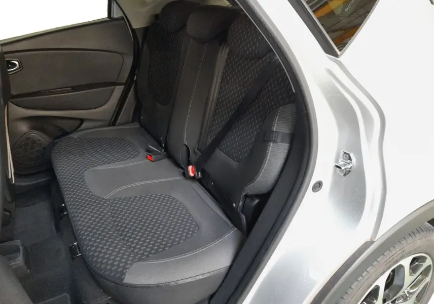 Vue côté droit arrière du Renault Captur gris clair métal, montrant l’ouverture de porte et la banquette arrière en tissu noir.