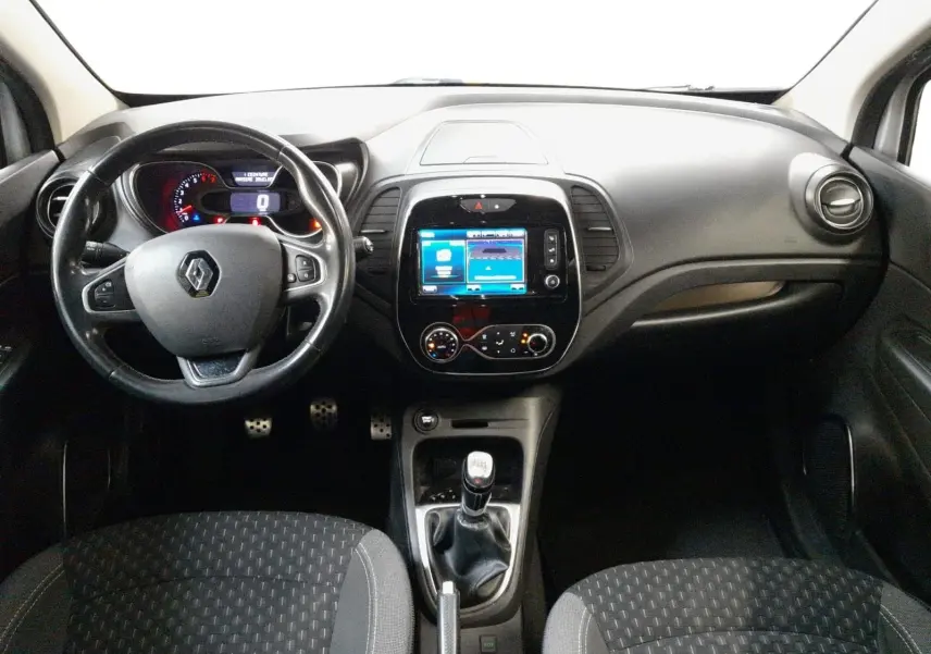 Vue intérieure frontale du tableau de bord du Renault Captur TCE 120 Energy Iridium 2017 avec volant, écran tactile et boîte manuelle.