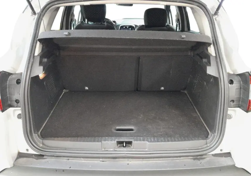 Coffre ouvert vu de l'arrière d'un Renault Captur gris clair métal avec intérieur noir et banquette arrière visible.