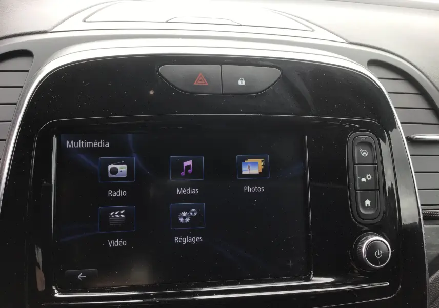 Écran tactile multimédia du tableau de bord d'une Renault Captur 2017, avec commandes et finition noire brillante.