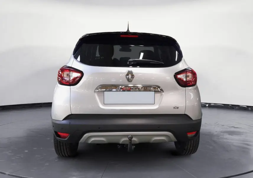 Vue arrière d'un Renault Captur gris clair métal avec toit noir, équipé d'une attache-remorque visible.