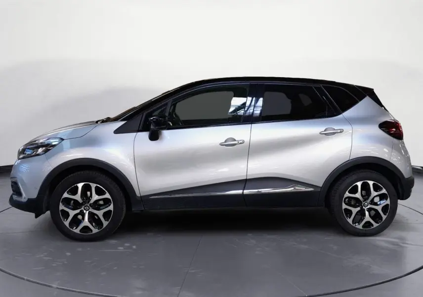 Profil droit du Renault Captur TCE 120 Energy Iridium 2017 en gris clair métal avec toit noir et jantes alliage 17 pouces.