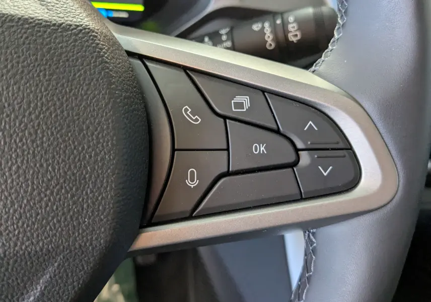 Gros plan sur les commandes multifonctions à droite du volant du Dacia Bigster Hybrid 155 gris schiste, boutons noirs et argentés.